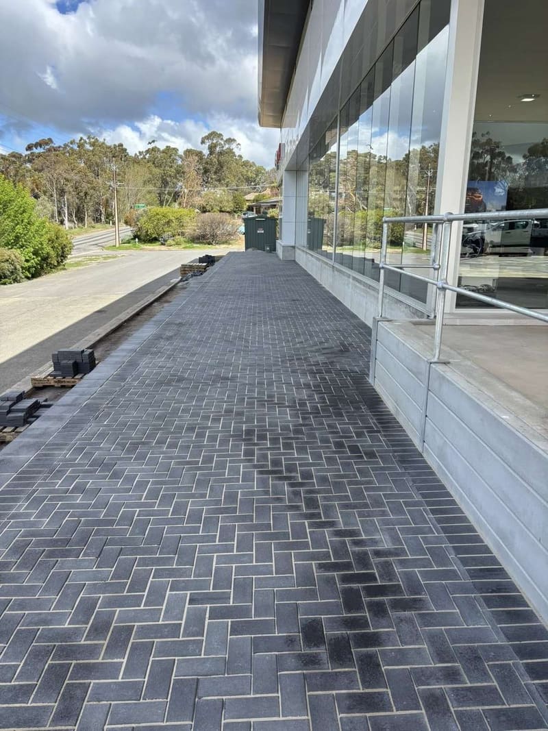 Commercial shopfront after — premium dark herringbone brick paving