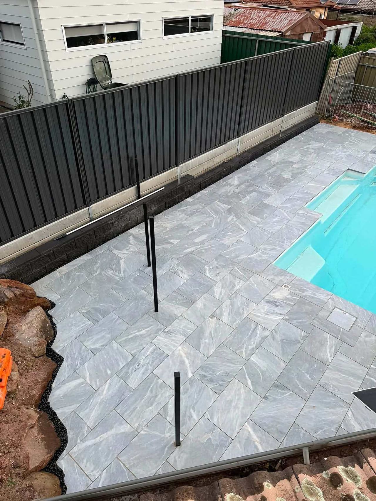 Marble-look pavers run clean to the pool's edge — May Paving